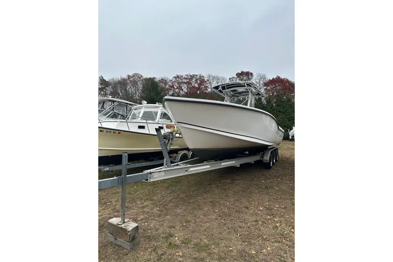 Slide: The Image of 2004 Ocean Master 31 Center Console boat docked with American flag, woman seated onboard. - 1