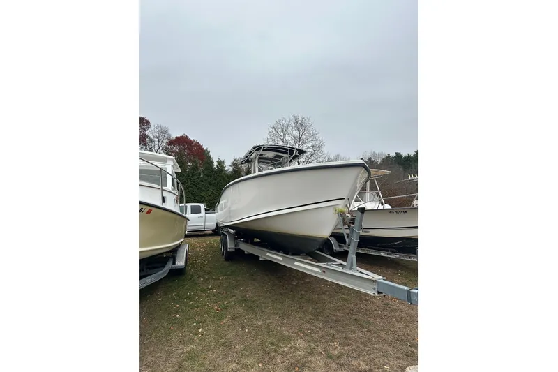 Slide: The Image of 2004 Ocean Master 31 Center Console boat docked with person onboard, American flag visible. - 2