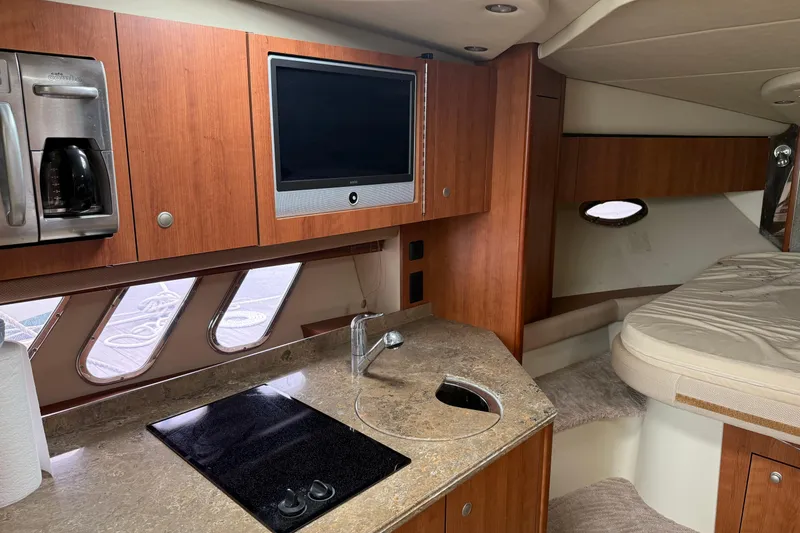 Slide: The Image of 2008 Cruisers Yachts 330 Express interior with kitchenette, TV, and sleeping area. - 7