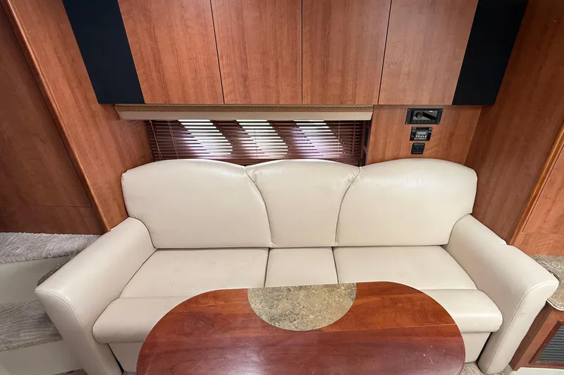 Slide: The Image of 2008 Cruisers Yachts 330 Express interior with beige sofa and wooden table. - 6