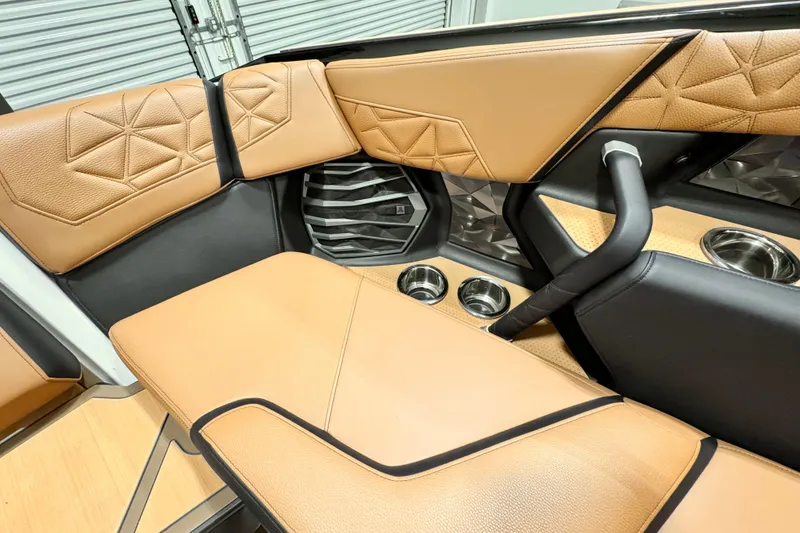 Slide: The Image of 2024 Nautique Super Air Nautique G23 Paragon interior with tan leather seating and cup holders. - 10