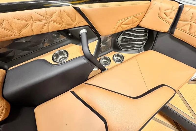 Slide: The Image of 2024 Nautique Super Air Nautique G23 Paragon interior with tan leather seats and cup holders. - 9