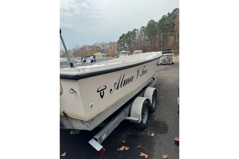 Slide: The Image of 1983 Sea Ox 23 boat on trailer, named "Alma V Toro," parked outdoors. - 3