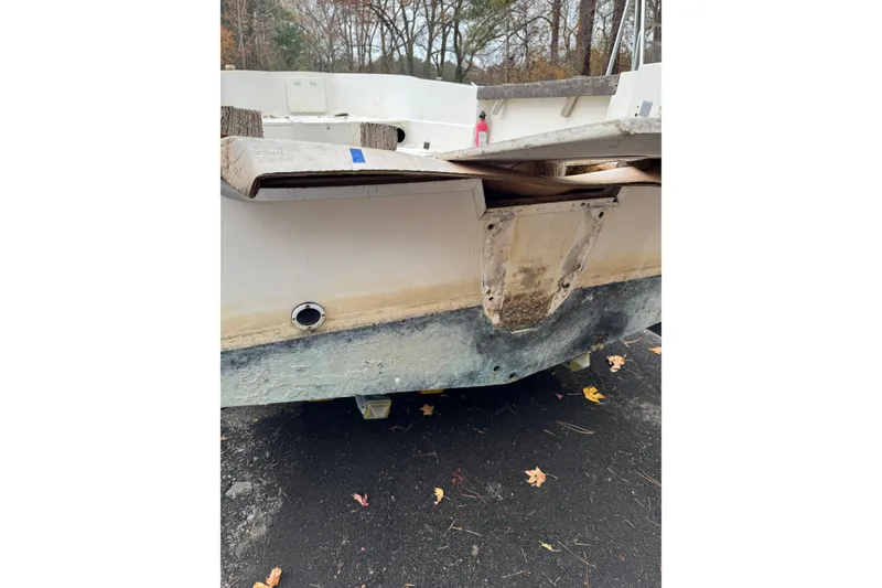 Slide: The Image of 1983 Sea Ox 23 boat with visible wear on the hull and transom. - 5