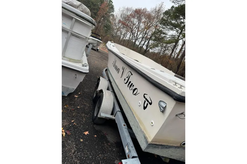 Slide: The Image of 1983 Sea Ox 23 boat on trailer, parked outdoors with trees in background. - 6