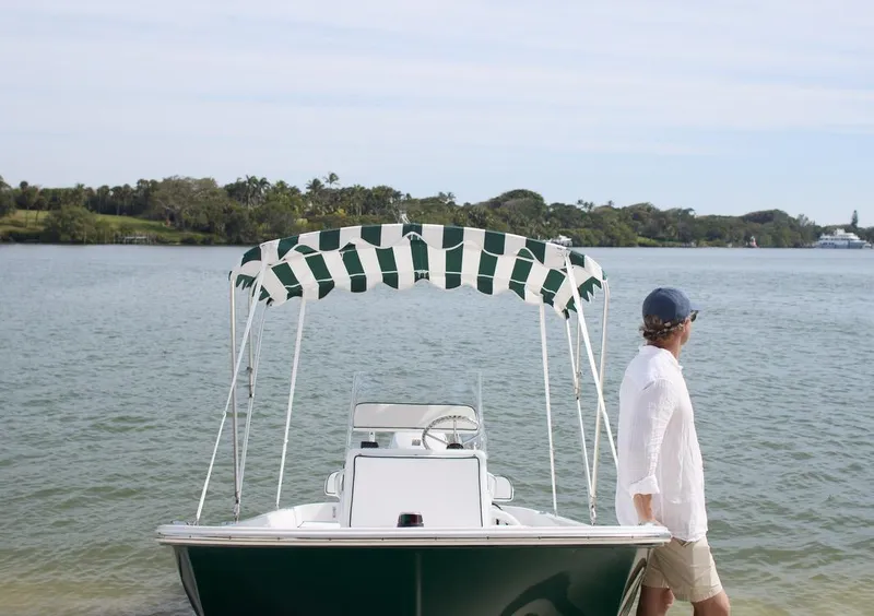 Slide: The Image of 2026 Palm Yachts 17 boat with striped canopy on a calm lake. - 4