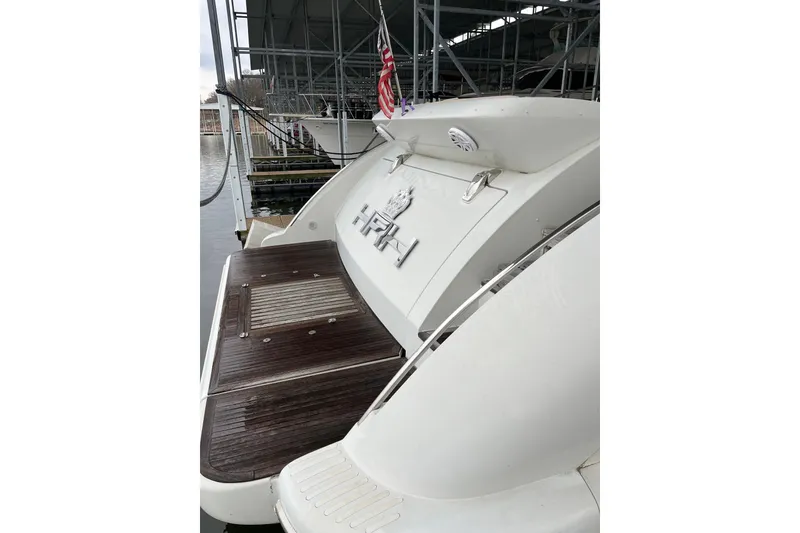 Slide: The Image of 2006 Azimut 68S yacht with wooden deck and American flag in marina. - 5