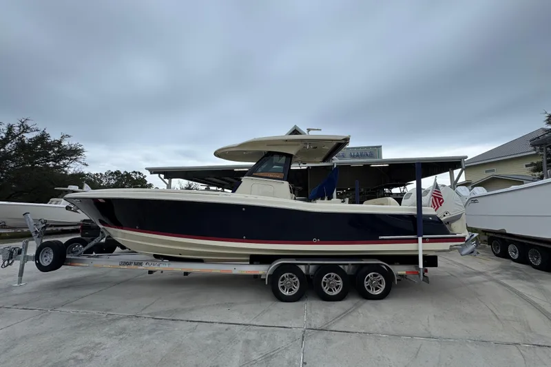 The Image of 2020 Chris-Craft Catalina 30 boat on trailer, displayed outdoors under cloudy sky. - 1