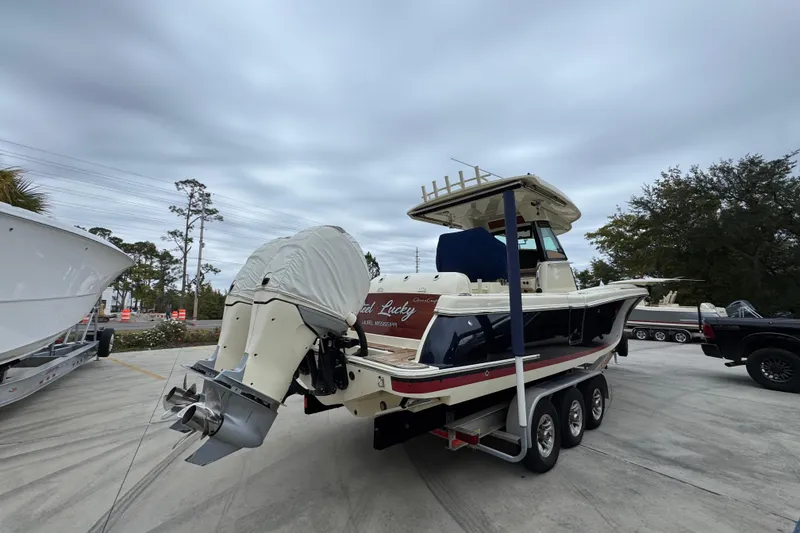 Slide: The Image of 2020 Chris-Craft Catalina 30 boat on trailer, parked outdoors under cloudy sky. - 12