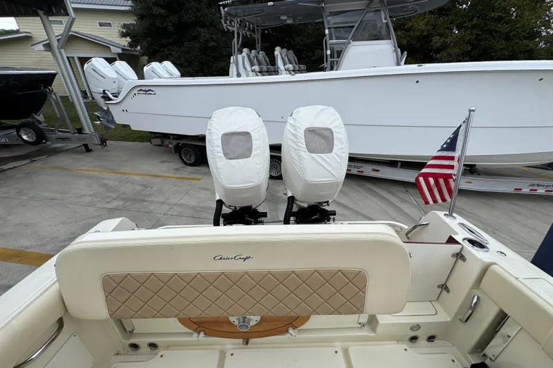 Slide: The Image of 2020 Chris-Craft Catalina 30 boat with covered engines and American flag, docked outdoors. - 42