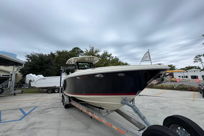 Slide: The Image of 2020 Chris-Craft Catalina 30 boat on trailer, parked outdoors under cloudy sky. - 7