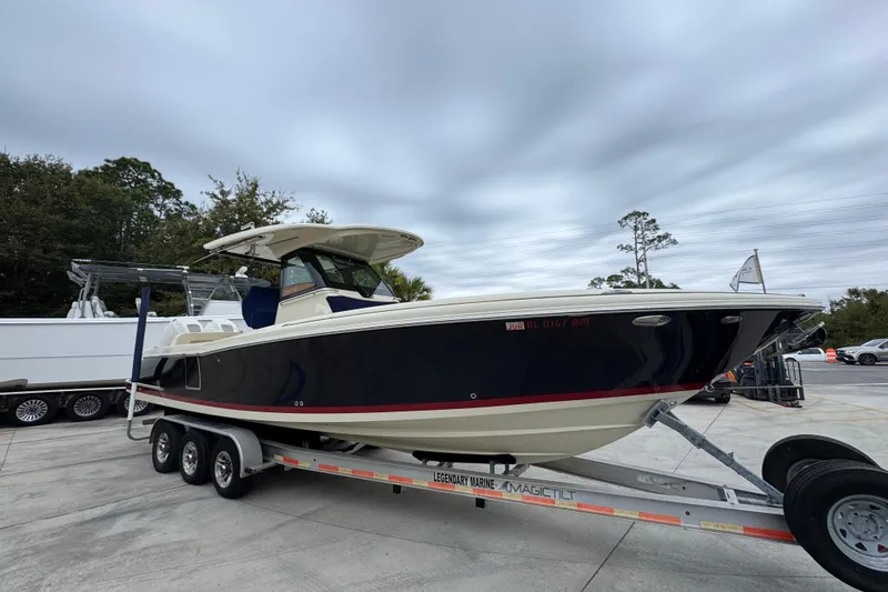 Slide: The Image of 2020 Chris-Craft Catalina 30 boat on trailer, parked outdoors under cloudy sky. - 8