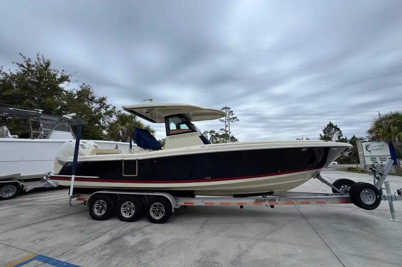 Slide: The Image of 2020 Chris-Craft Catalina 30 boat on trailer, parked outdoors under cloudy sky. - 9