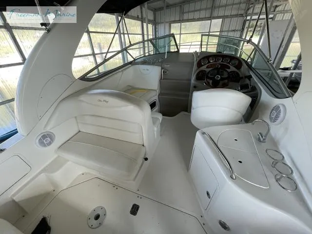 Slide: The Image of 2007 Sea Ray 280 Sundancer cockpit with helm, seating, and control panel in a covered dock. - 10