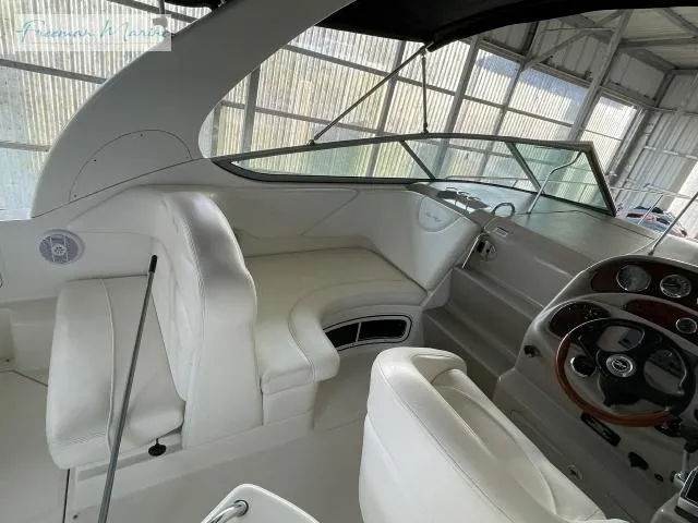 Slide: The Image of 2007 Sea Ray 280 Sundancer cockpit with white seating and steering wheel in a covered area. - 16