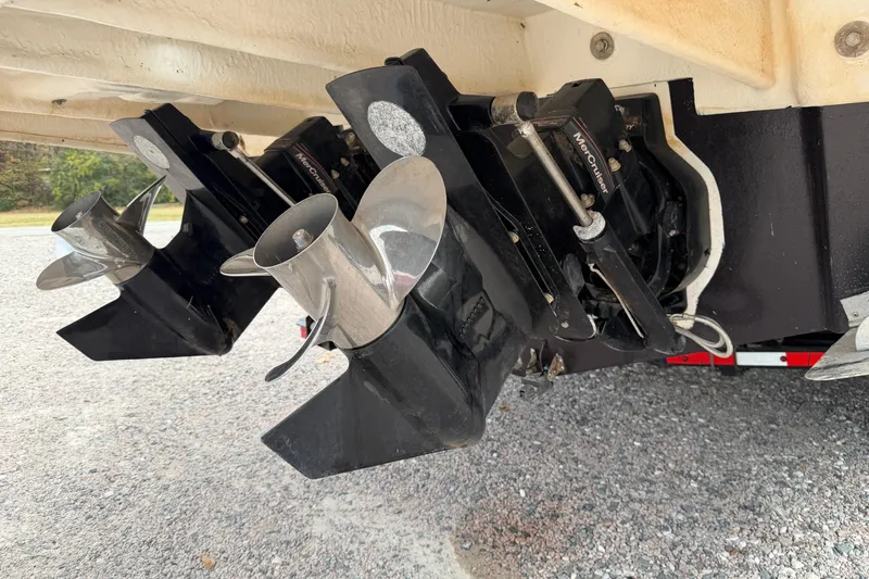 Slide: The Image of 2007 Sea Ray 280 Sundancer boat propellers and stern drive on gravel surface. - 22