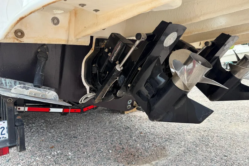 Slide: The Image of 2007 Sea Ray 280 Sundancer boat propellers and stern drive on gravel surface. - 23