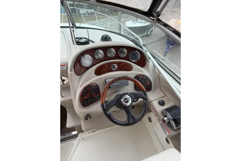 Slide: The Image of 2007 Sea Ray 280 Sundancer helm with wood-accented dashboard and steering wheel. - 31