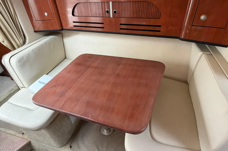 Slide: The Image of Interior of 2007 Sea Ray 280 Sundancer with wooden table and cream seating. - 36