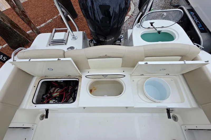 Slide: The Image of 2018 NauticStar 2302 Legacy boat with open storage compartments and engine view. - 10