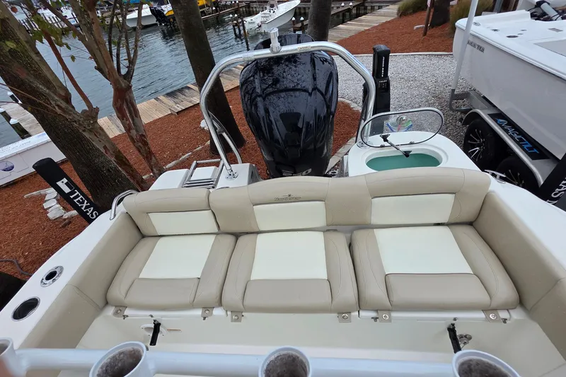 Slide: The Image of 2018 NauticStar 2302 Legacy boat interior with cushioned seating and outboard motor. - 12