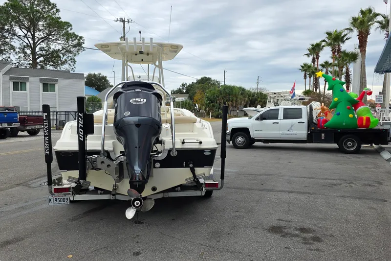 Slide: The Image of 2018 NauticStar 2302 Legacy boat on trailer, parked near truck with inflatable Christmas decorations. - 4