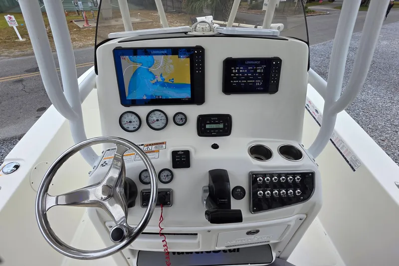 Slide: The Image of 2018 NauticStar 2302 Legacy boat dashboard with navigation screens and controls. - 5