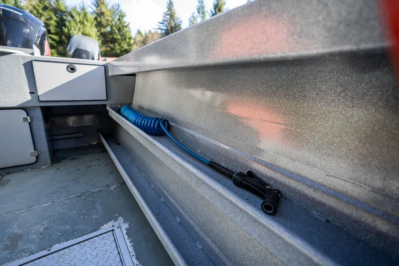 Slide: The Image of 2021 KingFisher 2825 Coastal Express boat interior with storage compartment and coiled hose. - 11