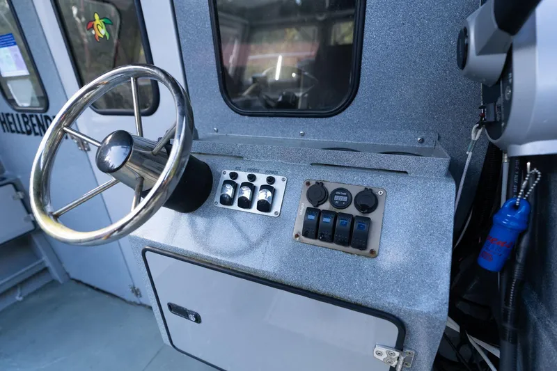Slide: The Image of Steering console of 2021 KingFisher 2825 Coastal Express boat, featuring control panel and wheel. - 16