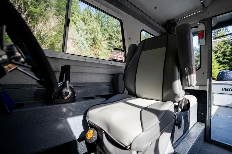 Slide: The Image of Interior of 2021 KingFisher 2825 Coastal Express boat, featuring a comfortable captain's seat. - 21