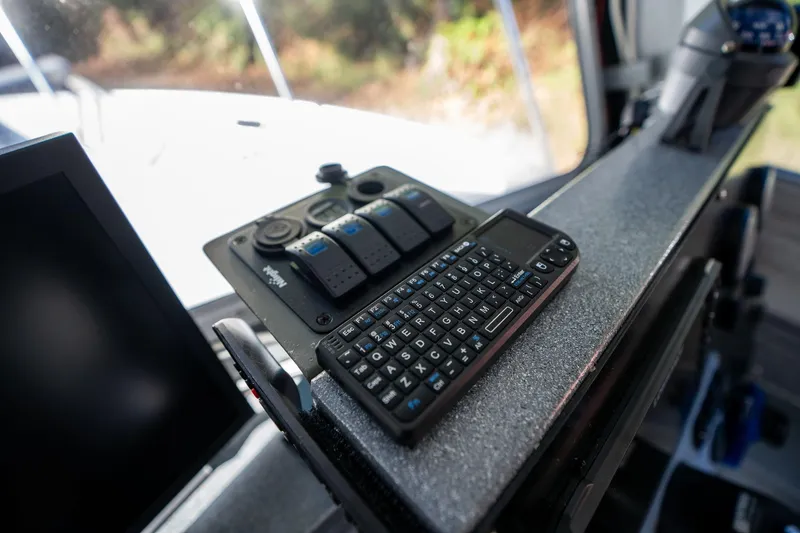 Slide: The Image of Control panel and keyboard inside 2021 KingFisher 2825 Coastal Express boat cockpit. - 27