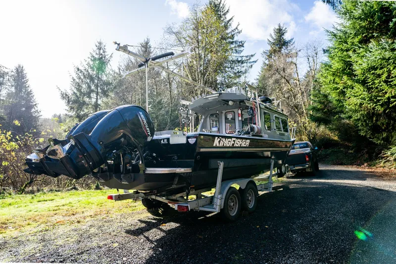 Slide: The Image of 2021 KingFisher 2825 Coastal Express boat on trailer in forested area. - 3
