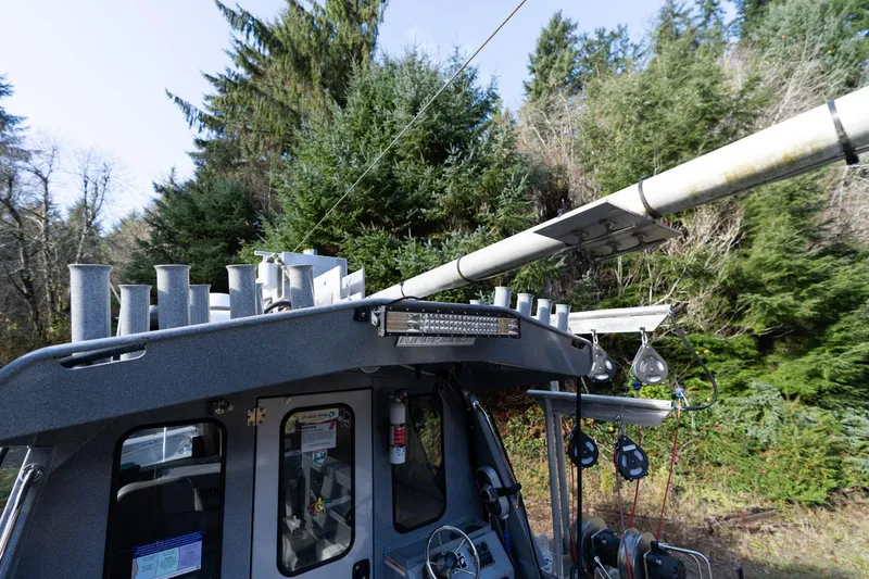 Slide: The Image of 2021 KingFisher 2825 Coastal Express boat with fishing equipment, surrounded by lush greenery. - 46