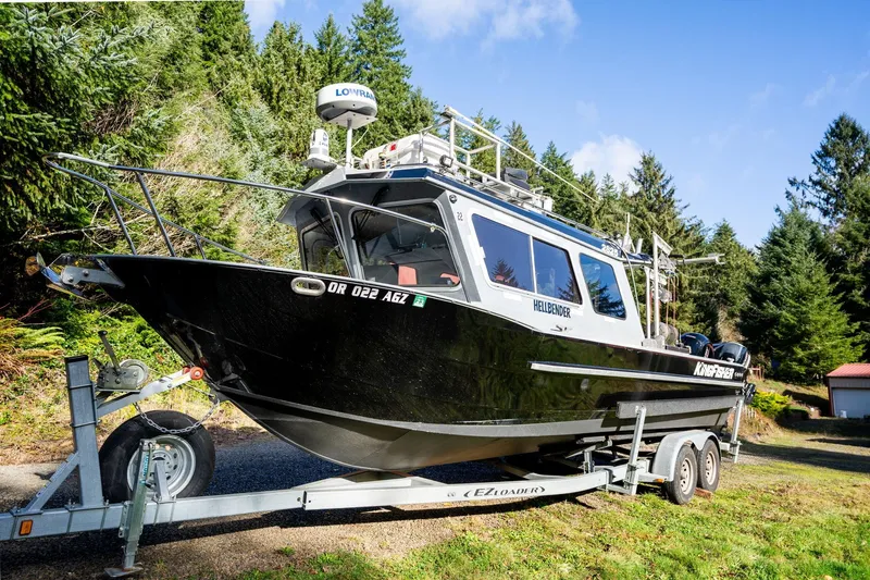 Slide: The Image of 2021 KingFisher 2825 Coastal Express boat on trailer, surrounded by lush greenery. - 50