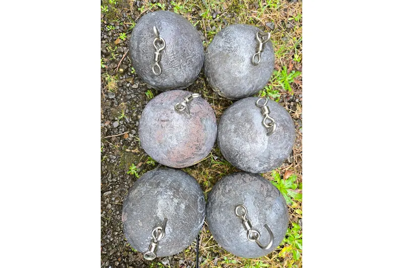 Slide: The Image of Six round fishing weights with swivels on grassy ground. - 64