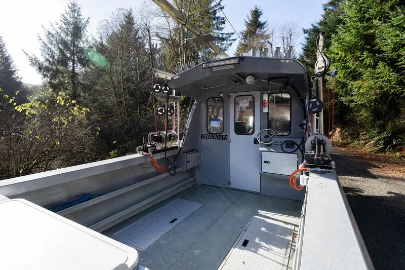 Slide: The Image of 2021 KingFisher 2825 Coastal Express boat interior with fishing equipment, surrounded by trees. - 7