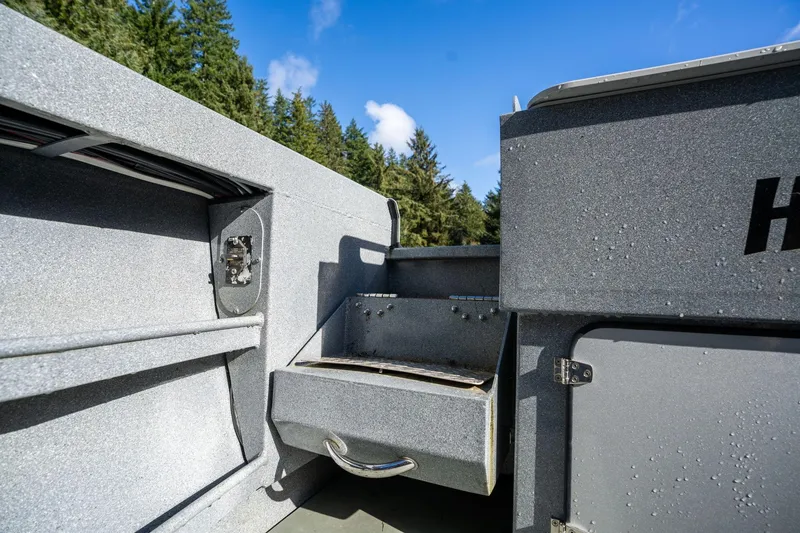 Slide: The Image of 2021 KingFisher 2825 Coastal Express boat interior with storage compartment, under clear blue sky. - 8