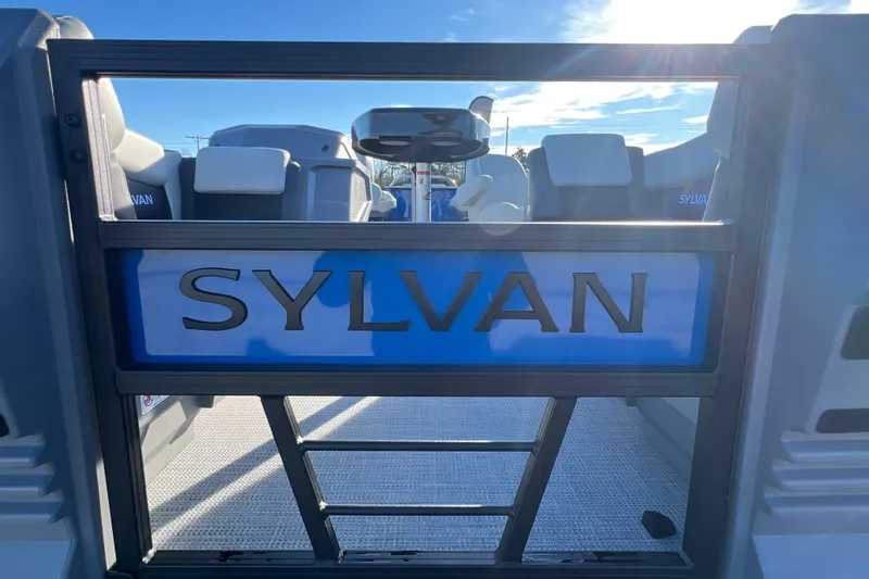 Slide: The Image of 2026 Sylvan R22 Rear Partyfish boat interior with logo, under bright sunlight. - 1