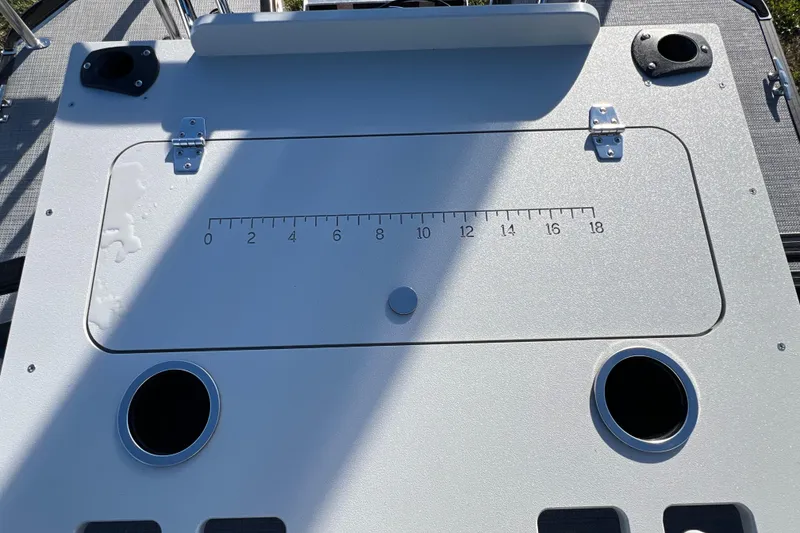 Slide: The Image of Control panel of 2026 Sylvan R22 Rear Partyfish boat with measurement scale and cup holders. - 11