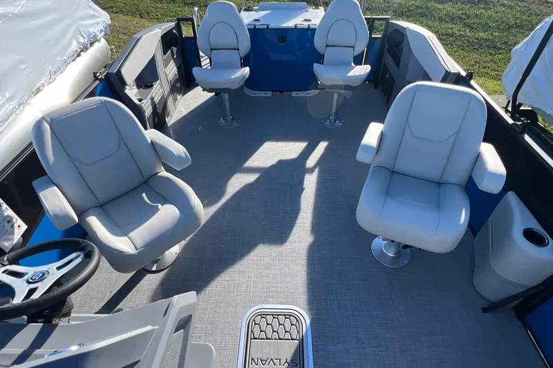 Slide: The Image of 2026 Sylvan R22 Rear Partyfish boat interior with four swivel chairs and steering wheel. - 6