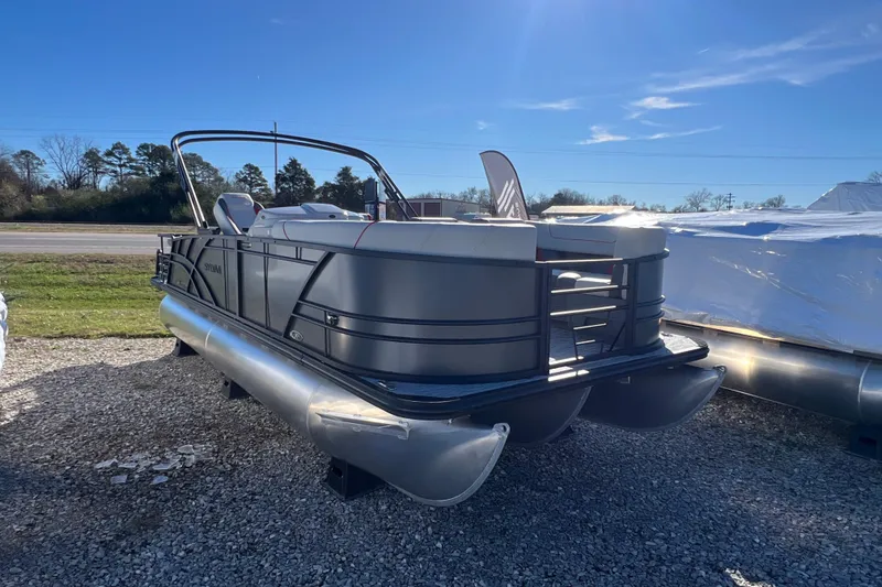The Image of 2026 Sylvan X3 DLZ Bar pontoon boat on gravel lot under clear blue sky. - 0