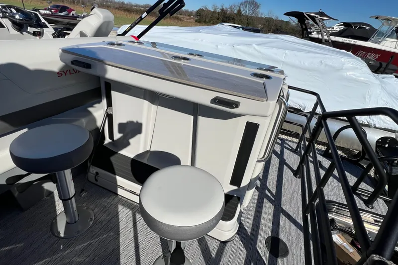 Slide: The Image of 2026 Sylvan X3 DLZ Bar boat interior with stools and table setup. - 12