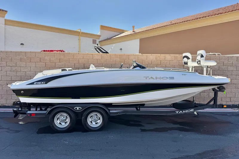 The Image of 2020 Tahoe 215 Xi boat on trailer, parked outdoors with a brick wall backdrop. - 0