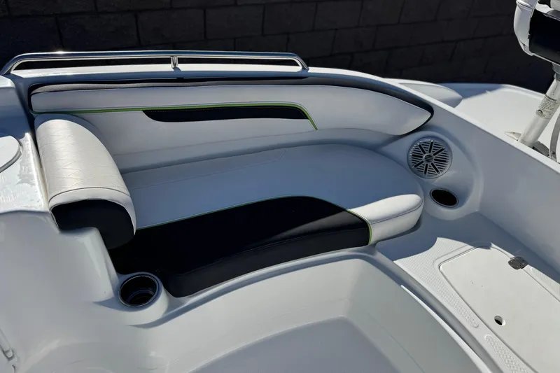 Slide: The Image of 2020 Tahoe 215 Xi boat interior with white and black seating, cup holders, and speaker. - 14
