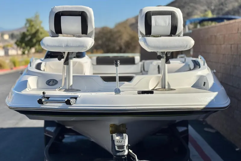 Slide: The Image of 2020 Tahoe 215 Xi boat with dual seats, parked outdoors, showcasing sleek design. - 2