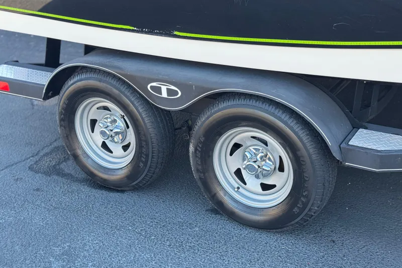 Slide: The Image of Trailer wheels of a 2020 Tahoe 215 Xi boat on pavement. - 28