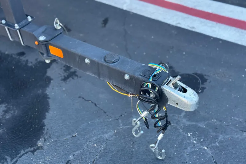 Slide: The Image of Trailer hitch with wiring for 2020 Tahoe 215 Xi on asphalt surface. - 29