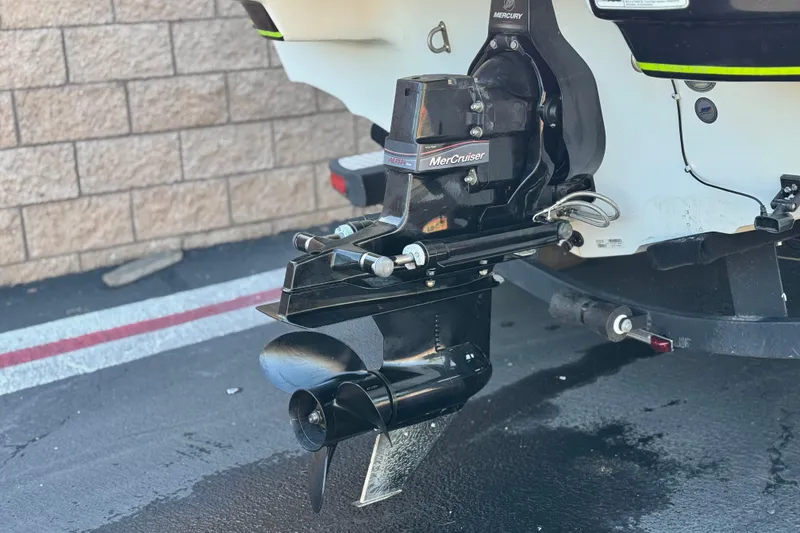 Slide: The Image of 2020 Tahoe 215 Xi boat with MerCruiser outboard motor, parked on pavement. - 6