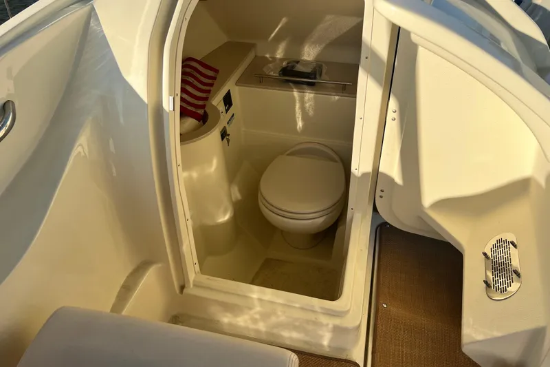 Slide: The Image of 2017 Chris-Craft Calypso 26 boat interior with compact bathroom and toilet. - 12