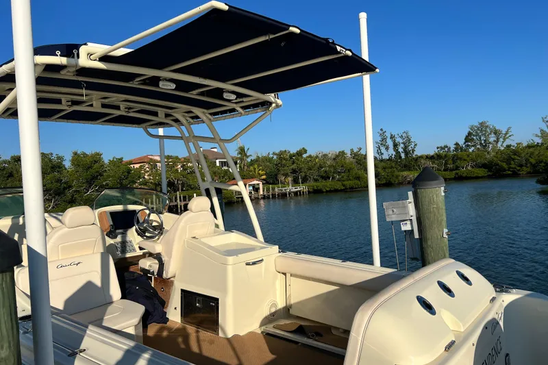 Slide: The Image of 2017 Chris-Craft Calypso 26 boat docked by a scenic waterfront. - 2